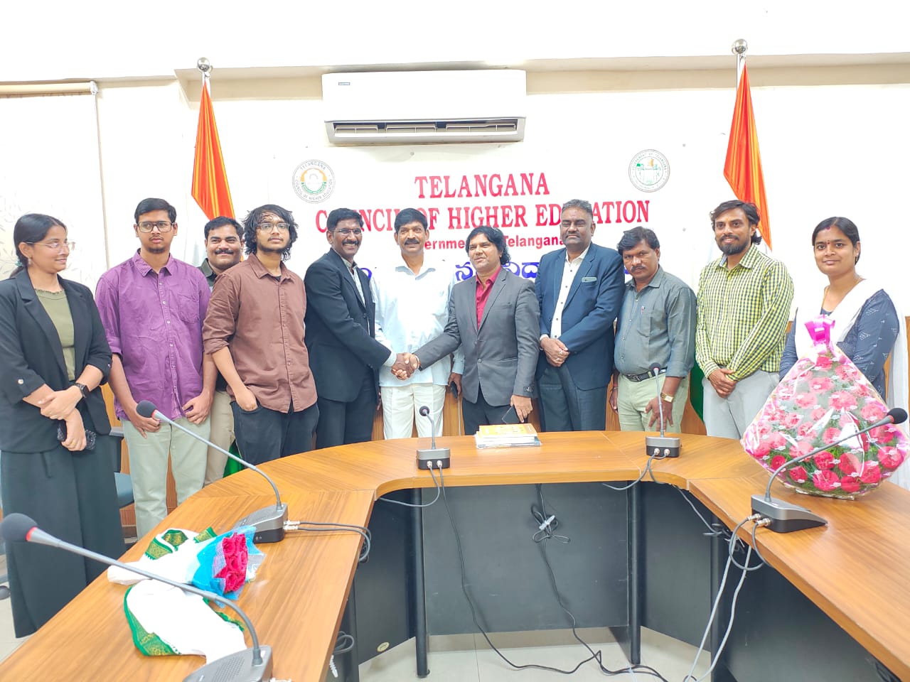 Officials shaking hands among students and the team at the Telangana Council of Higher Education